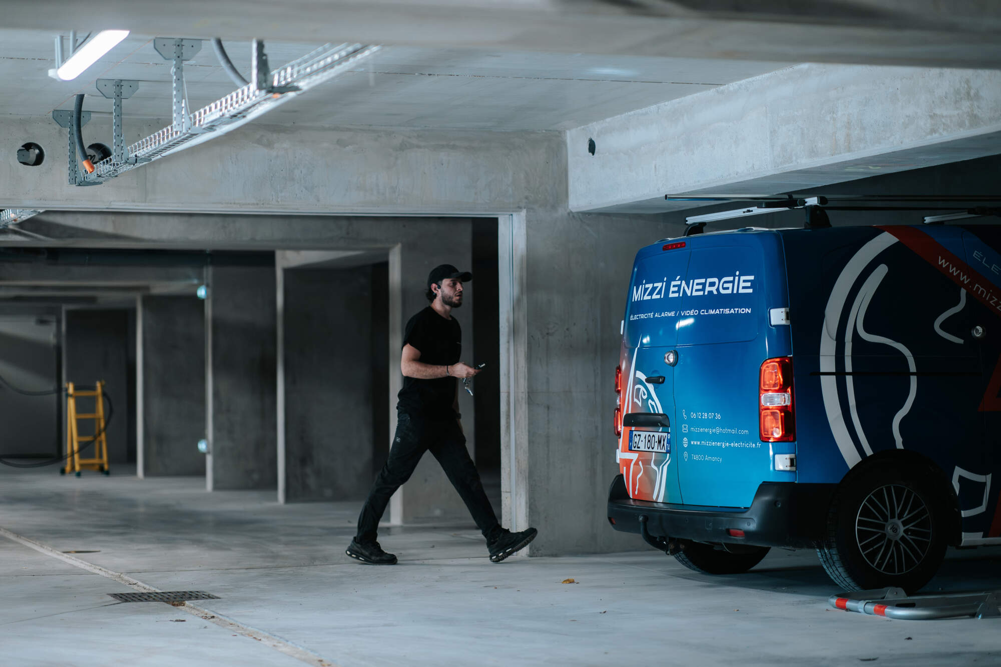 PHOTO D'UN VÉHICULE ET D'UN ÉLECTRICIEN DE L'ENTREPRISE MIZZI ÉNERGIE
