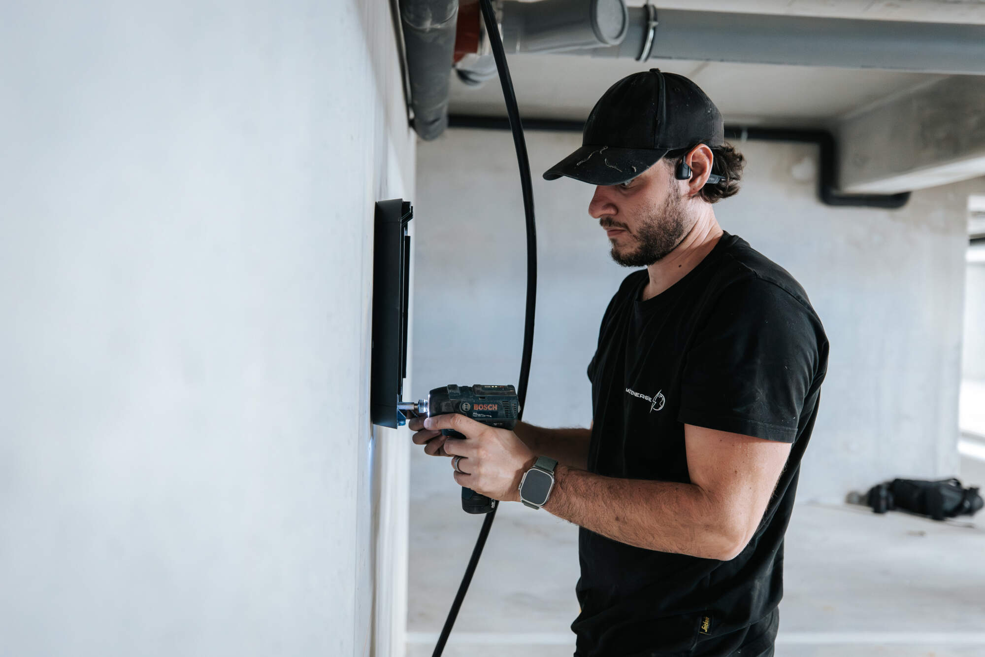 PHOTOO D'UN ÉLECTRICIEN ENTRAIN D'INSTALLER UN BOÎTIER ÉLECTRONIQUE