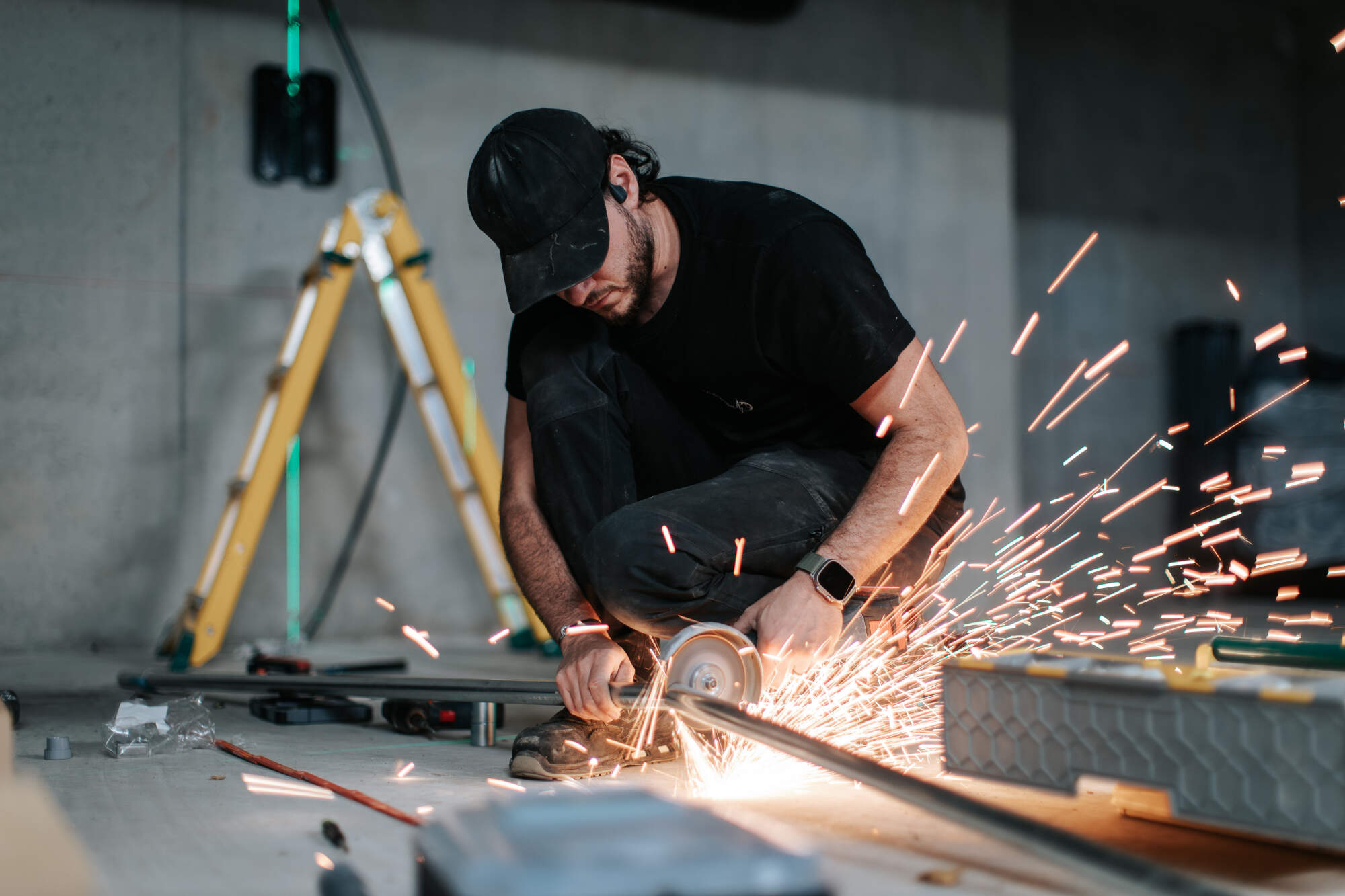 PHOTO D'UN ÉLECTRICIEN ENTRAIN DE SCIER UNE BARRE EN MÉTAL