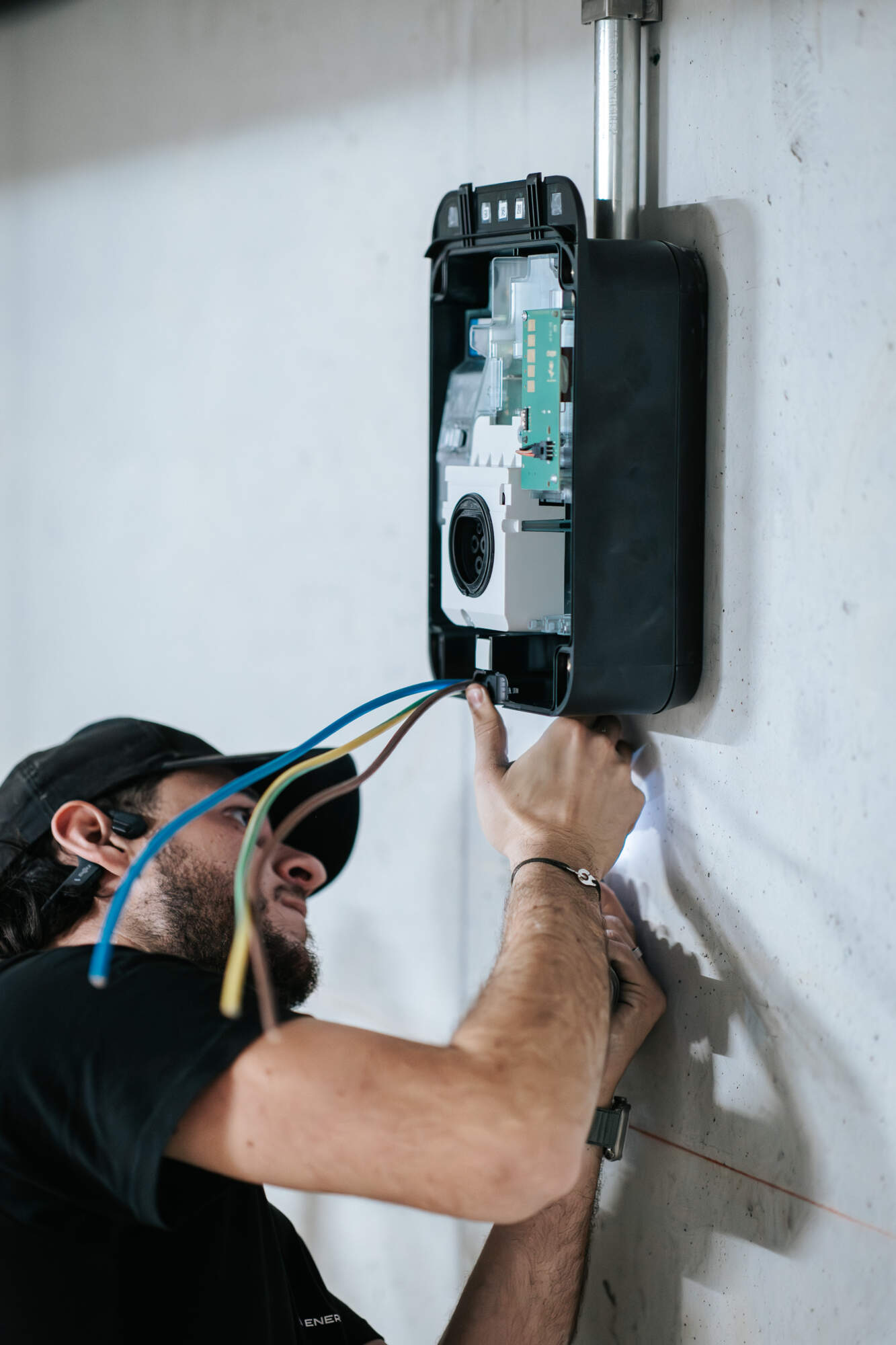 PHOTO D'UN ÉLECTRICIEN ENTRAIN D'INSTALLER UN BOÎTIER ÉLECTRIQUE